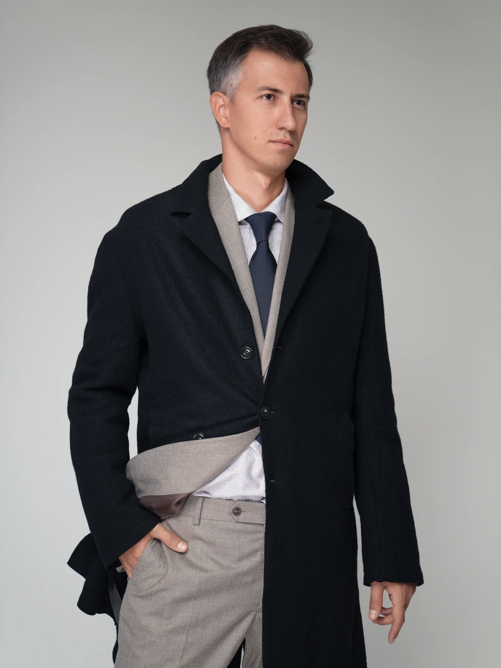 Business portrait of executive in coat with hand in pocket, Kuwait studio