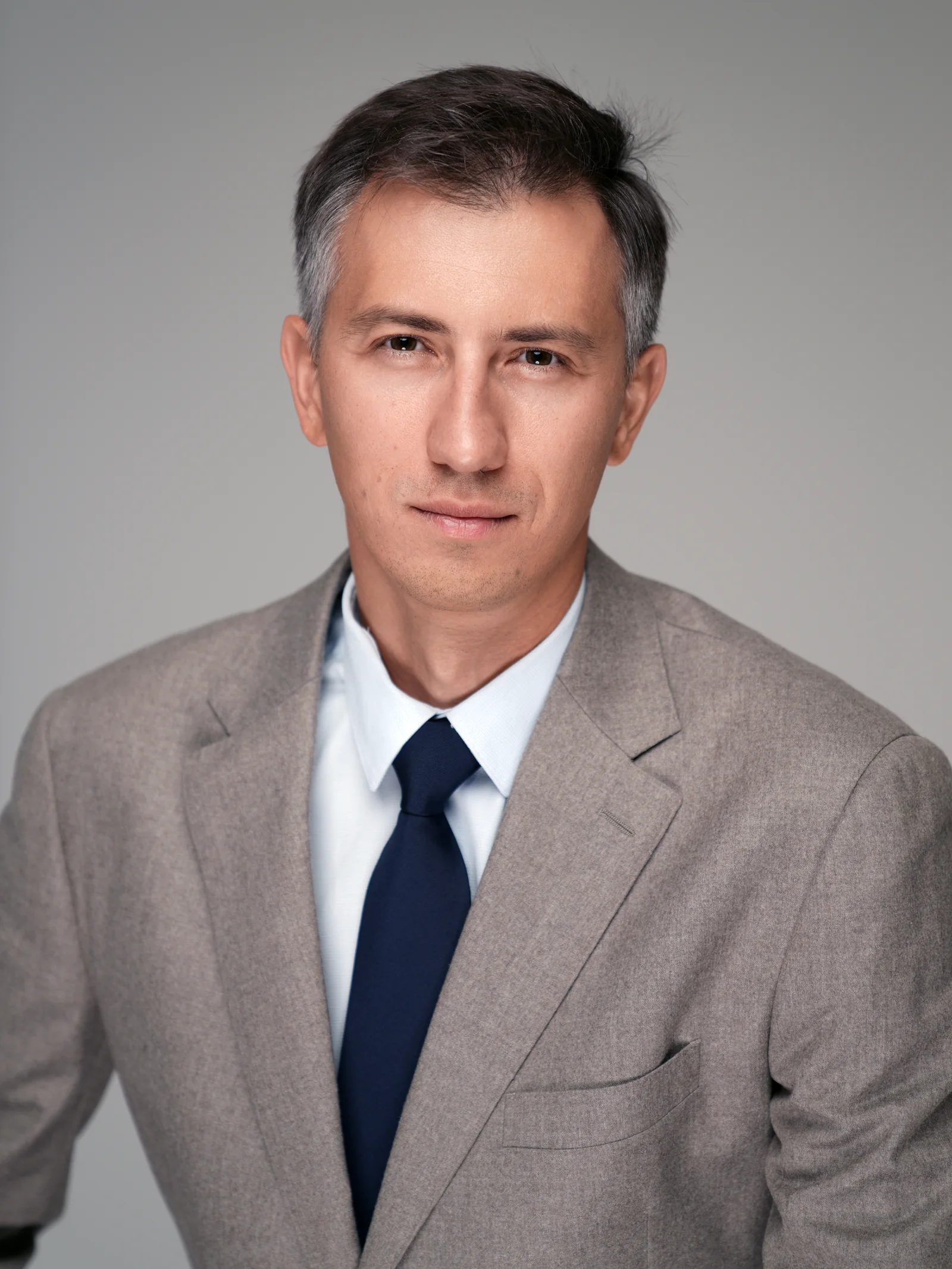 Corporate headshot of executive in beige suit and tie, Studio Letouch Kuwait