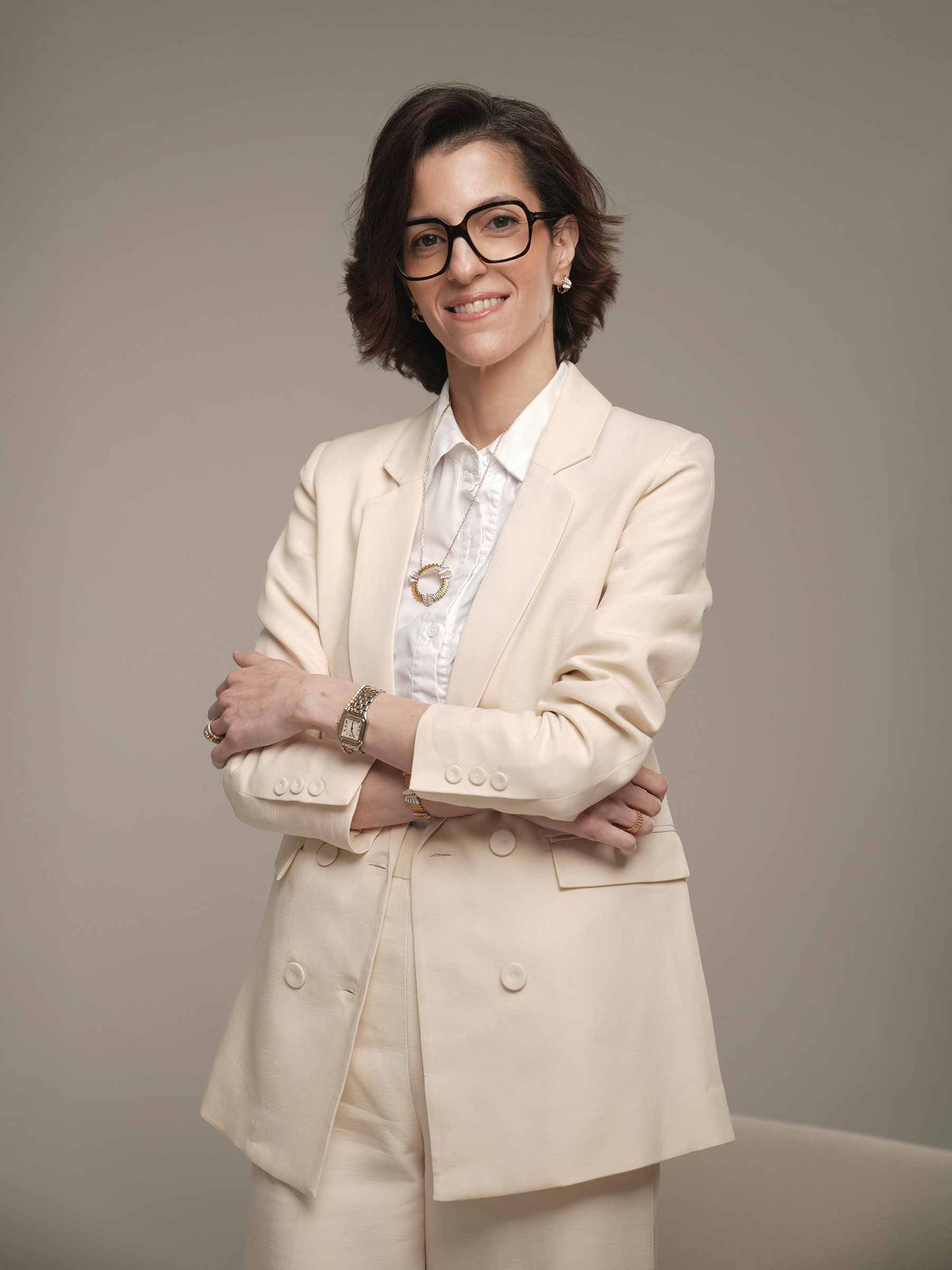 Standing personal branding portrait in a cream suit with arms crossed, Kuwait City studio