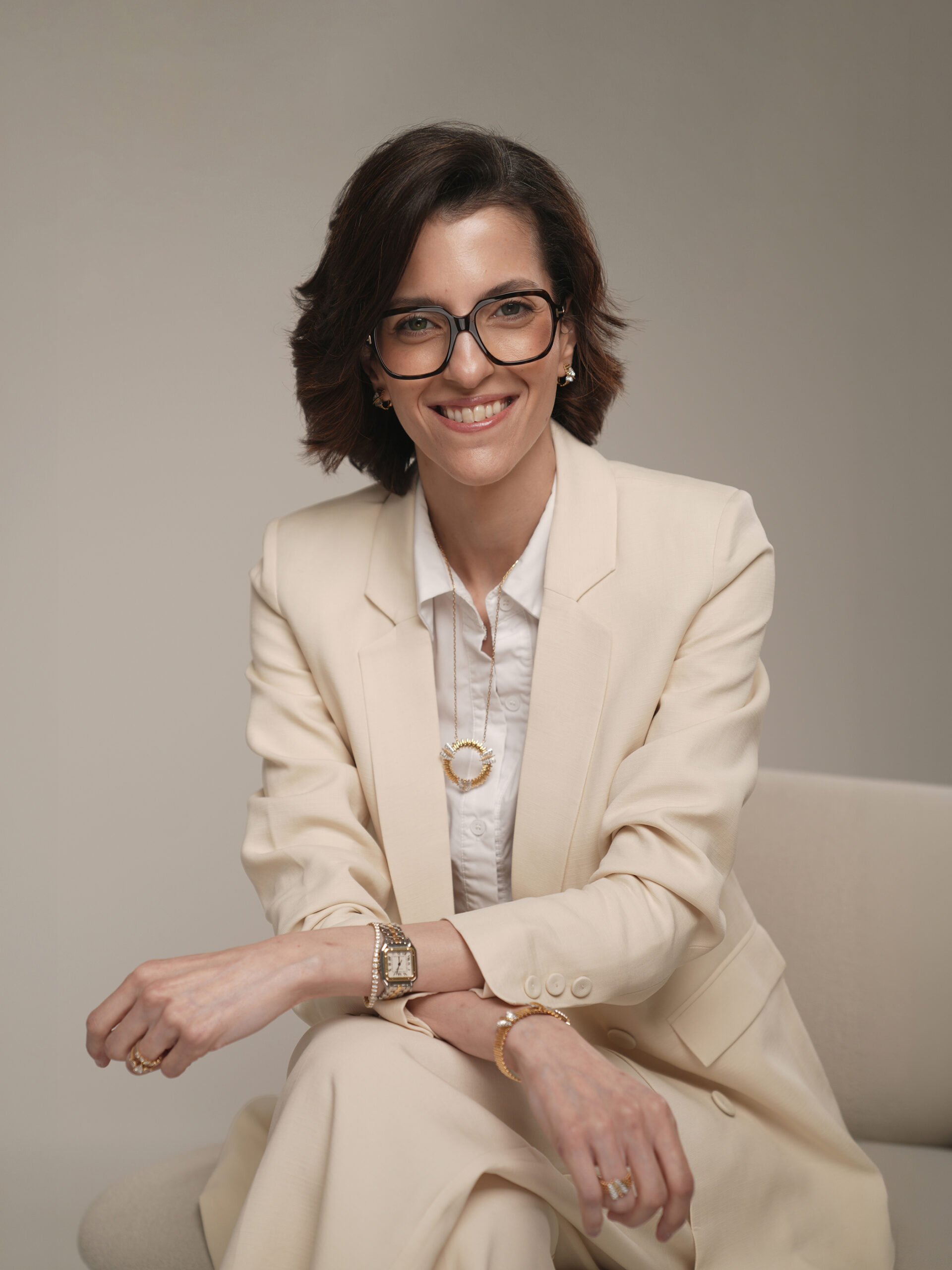 Seated personal branding portrait in a cream suit in soft directional studio light, Kuwait