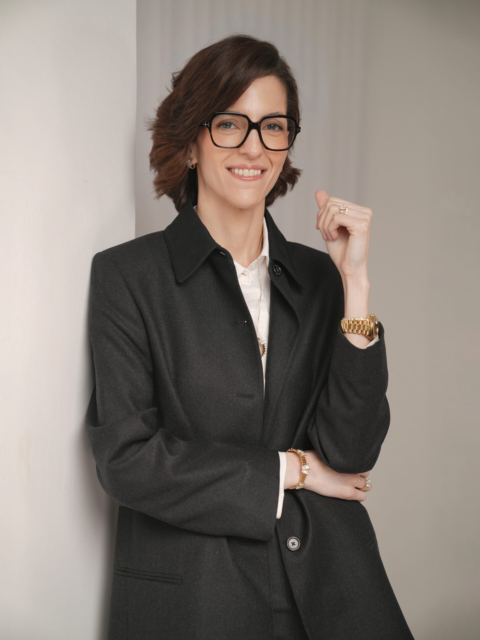 Personal branding portrait in a charcoal coat against a soft grey wall, Kuwait City
